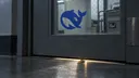 A brass key slips beneath a security door bearing the DeepSeek logo.