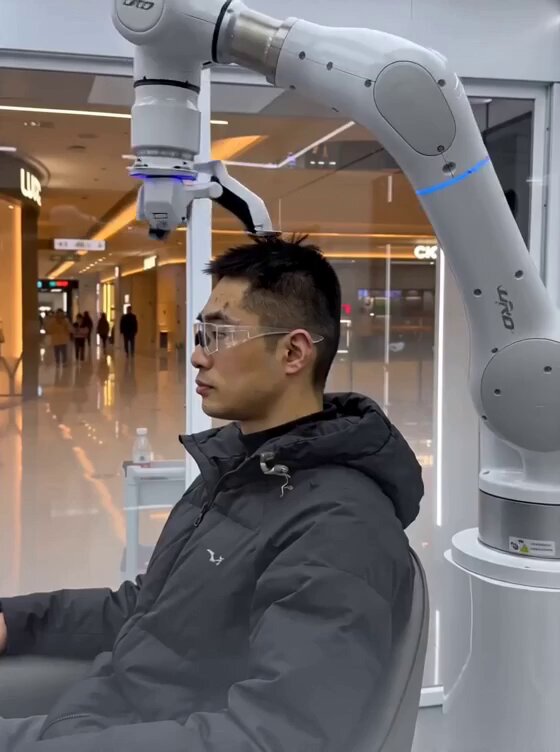 A video linked in the post, sourced from X, shows a walk-in booth scanning a customer's head in 3D before a robotic mechanism trims hair inside the kiosk.