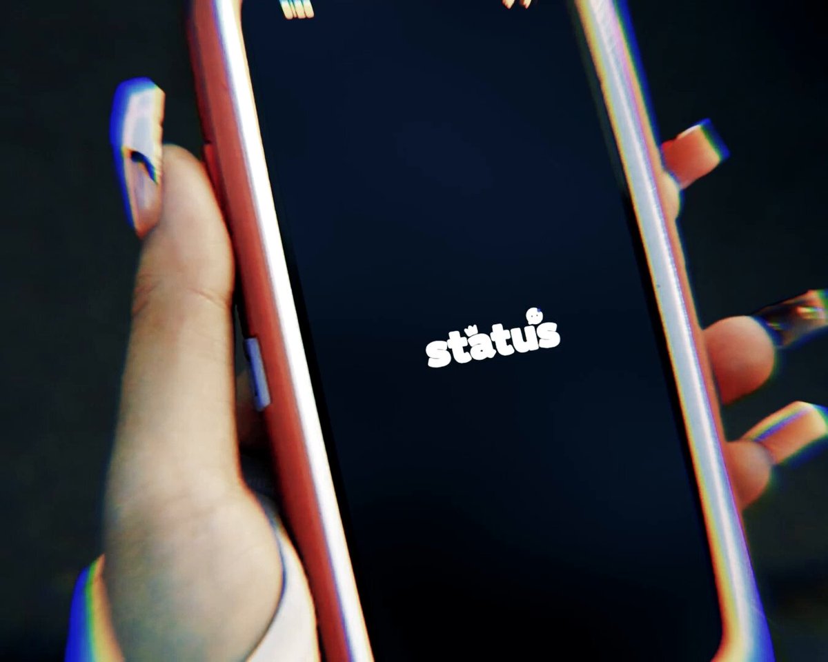 Person with long finger nails opening the Status app on their phone